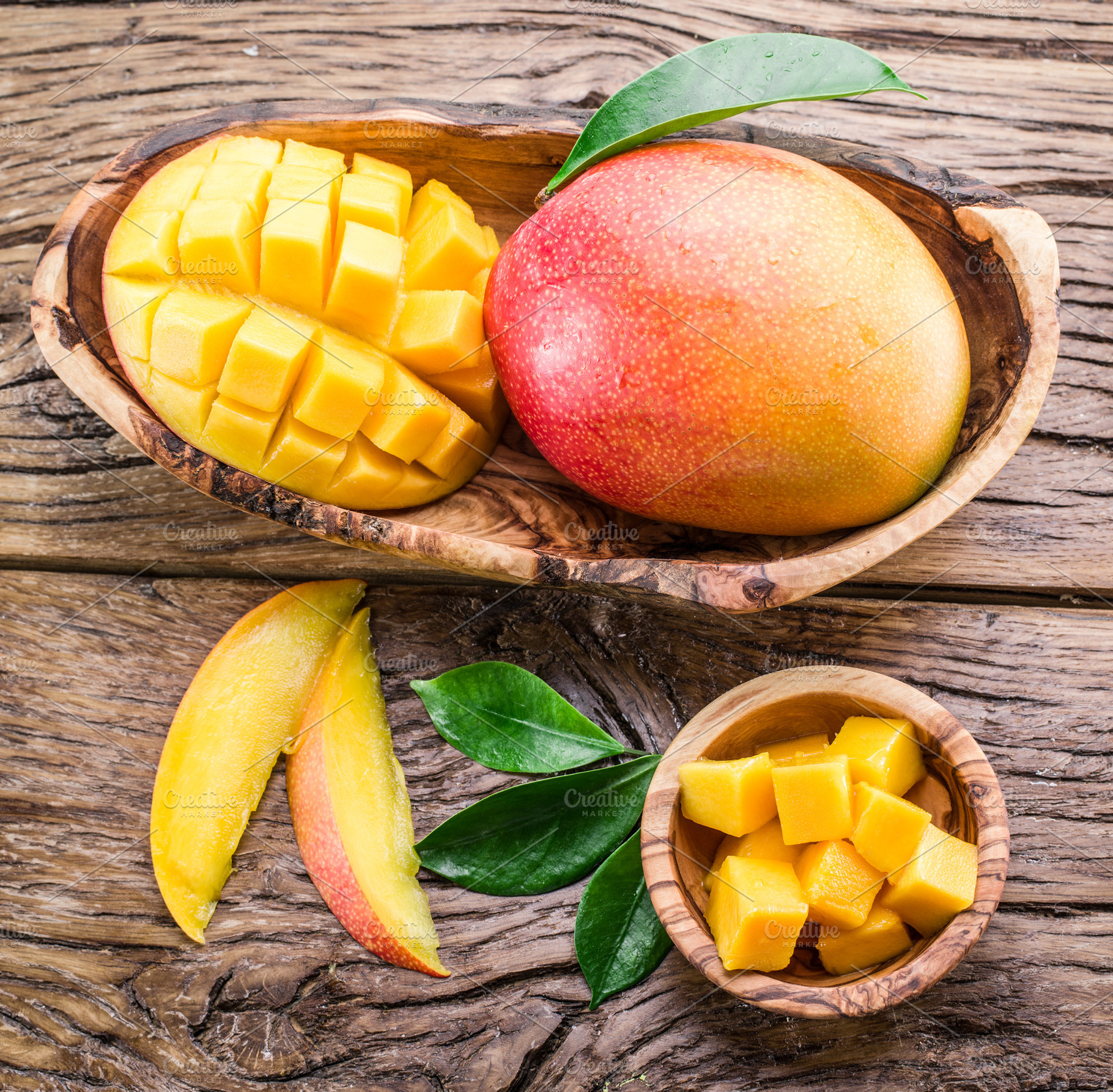 Mango fruit and mango cubes on the wooden table., a Food & Drink Photo by Volff