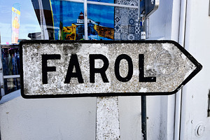 Rustic directional sign pointing to Farol in Nazare Portugal outdoors, a Photo by AS photostudio