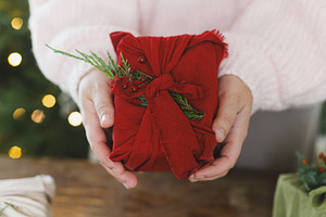 Zero waste christmas gift. Woman holding christmas present in re, a Holiday Photo by Sonjachni