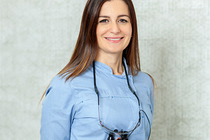 Portrait of smiling female dentist wearing magnifying glasses, a Health & Medical Photo by Antonio Gravante Market