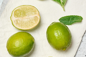 A minimalist composition featuring green whole limes and a juicy, a Food & Drink Photo by ndanko