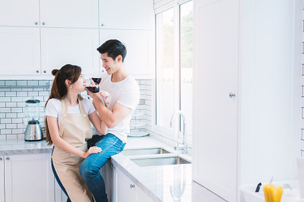 Asian lovers or couples drinking wine in kitchen room at home. L, a Person Photo by Ministocker