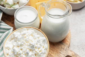 Assortment of fresh dairy products on wooden cutting board, a Food & Drink Photo by Olena Rudo