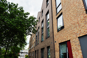 Modern brick apartment building and tree lined walkway on a resi
