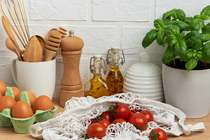 Cherry tomatoes, basil and eggs resting on kitchen counter, embo, a Food & Drink Photo by Olena Rudo