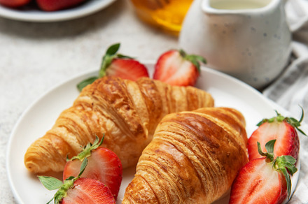 Delicious french croissants with fresh strawberries and honey fo