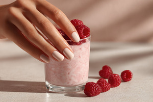 Hand picking raspberries from glass