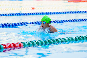 Swimmer child swims breaststroke swimming style in a race swimmi