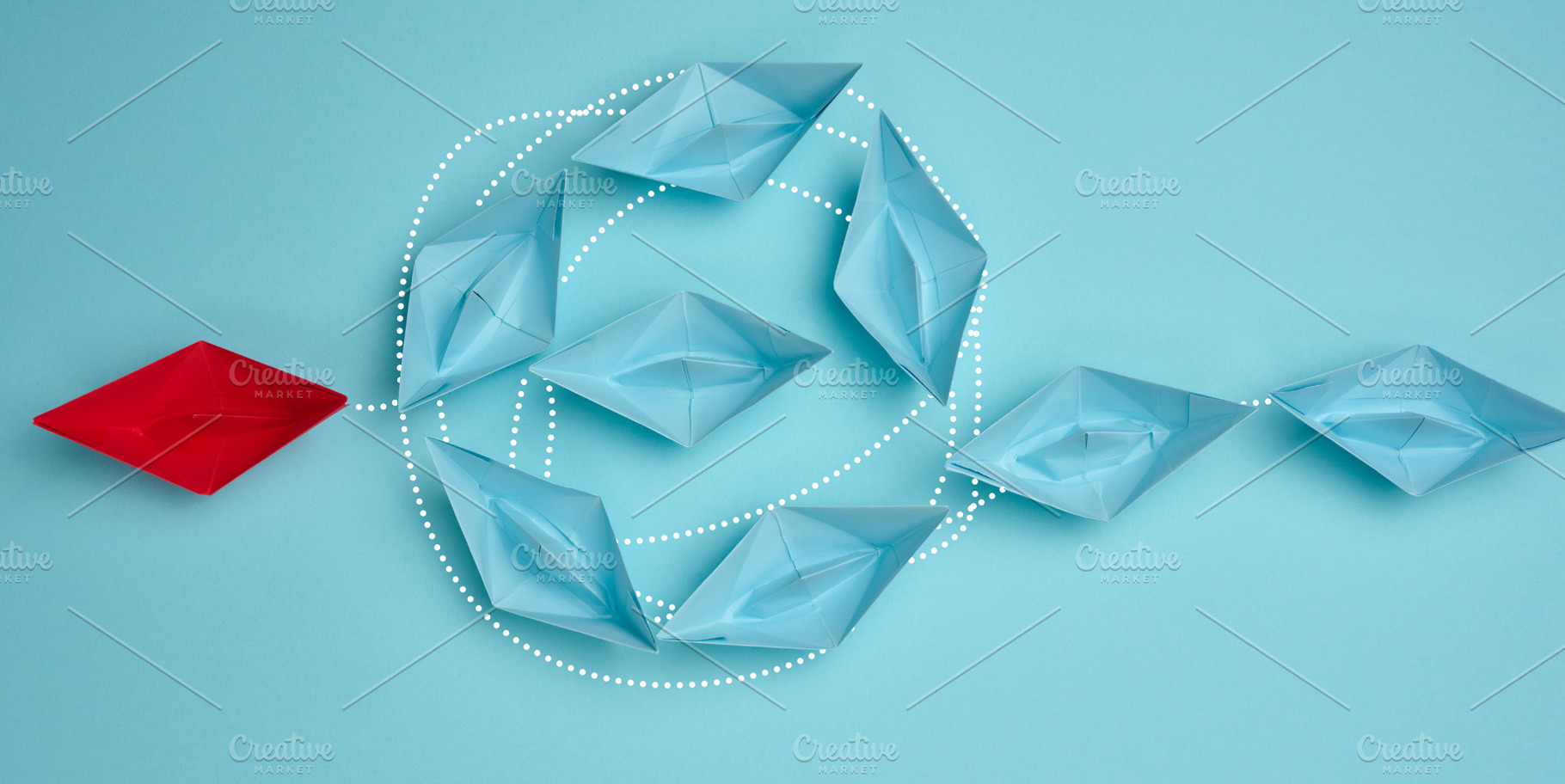 A red paper boat leads blue boats connected by dotted lines, a Business Photo by ndanko