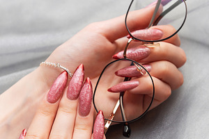Feminine hands holding eyeglasses with stylish pink manicure, a Beauty & Fashion Photo by Olena Rudo