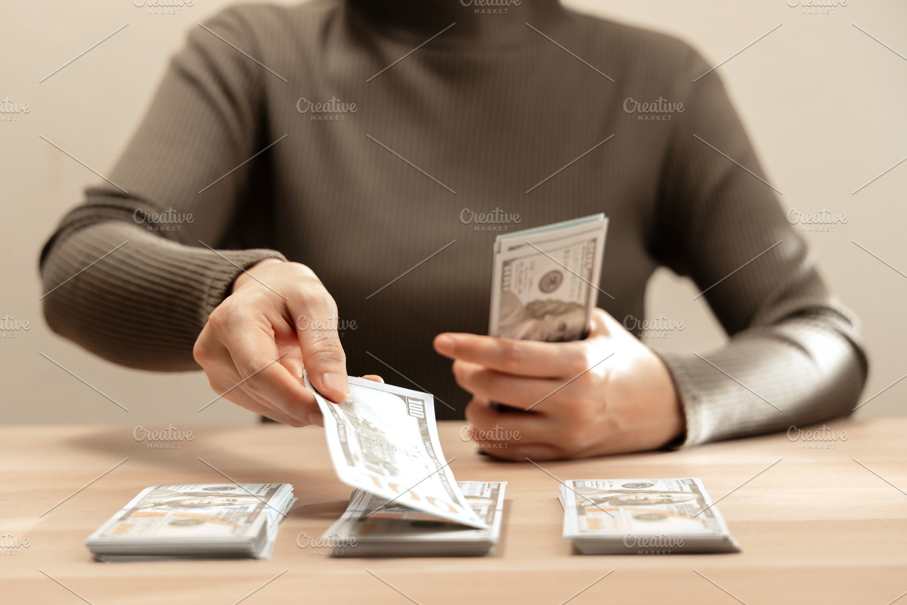 Sorting cash money into piles on a wooden table. Personal financ, a Photo by salmon.black