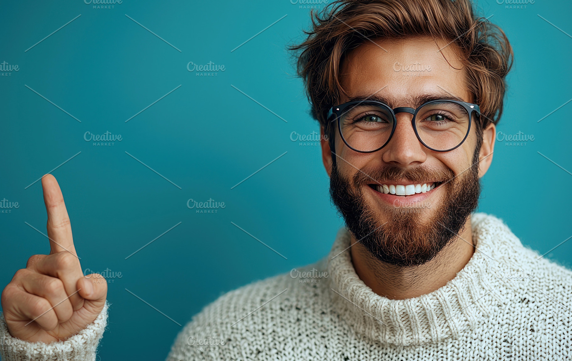 Smiling bearded man with glasses pointing upward against teal ba, a Person Photo by José Manuel Gelpi