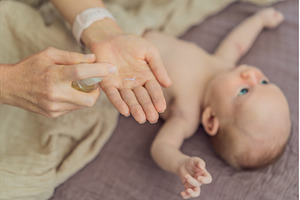 A mother gently massages her 1-month, a Person Photo by Elizaveta Galitskaya