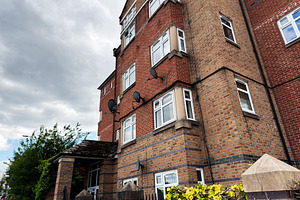 Brick apartment building with satellite dishes and bay windows u