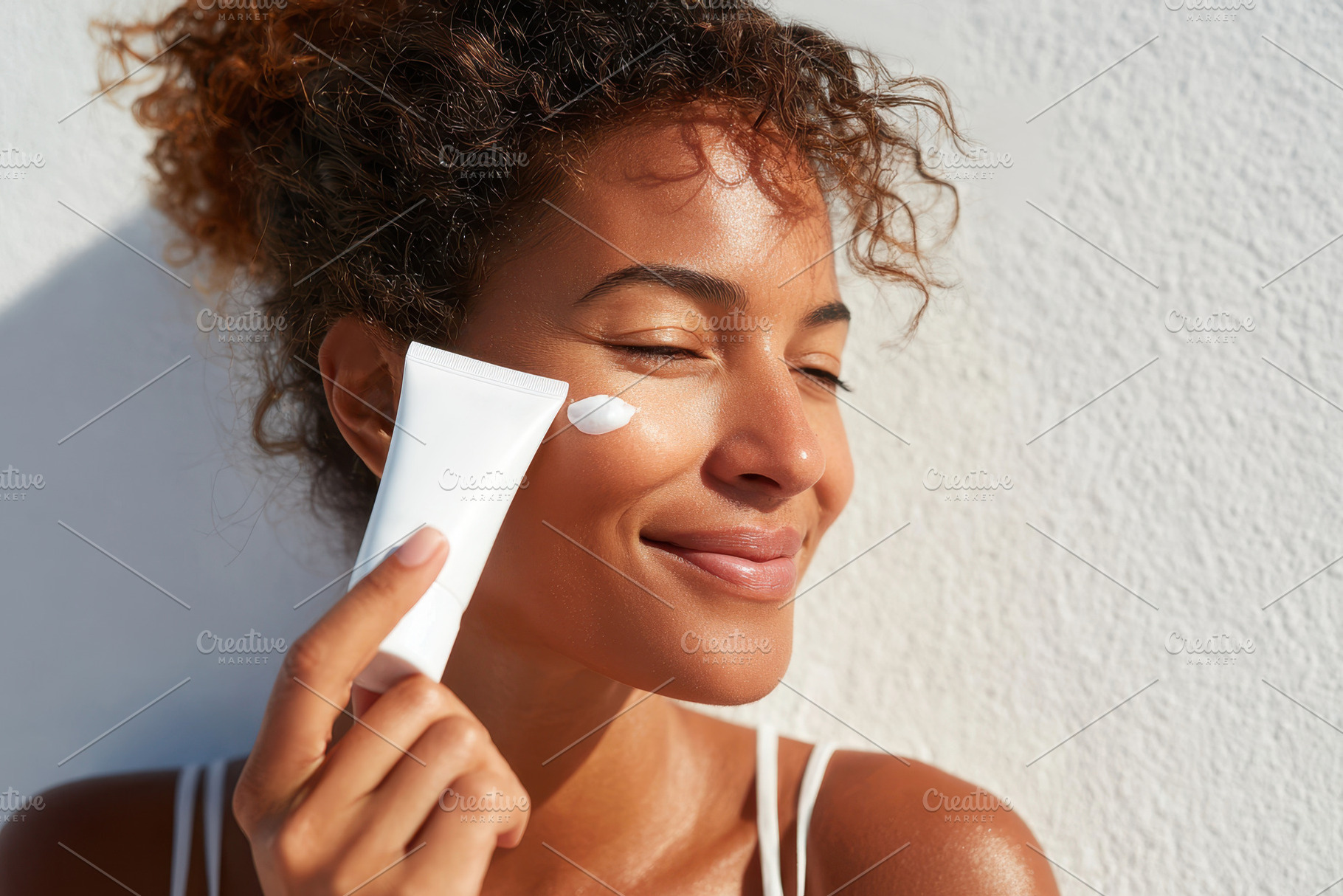 Woman applying skincare cream with a smile, a Person Photo by AlyaAnd
