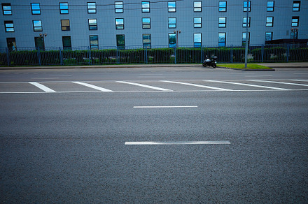 Lonely motorcycle on empty car parking backdrop, a Transportation Photo by RETROWAVE '88