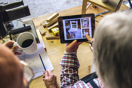 Senior couple in a carpentry looking tablet, a Person Photo by davidpereiras