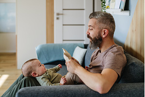 Father holding baby boy on his lap., a Person Photo by HalfPoint