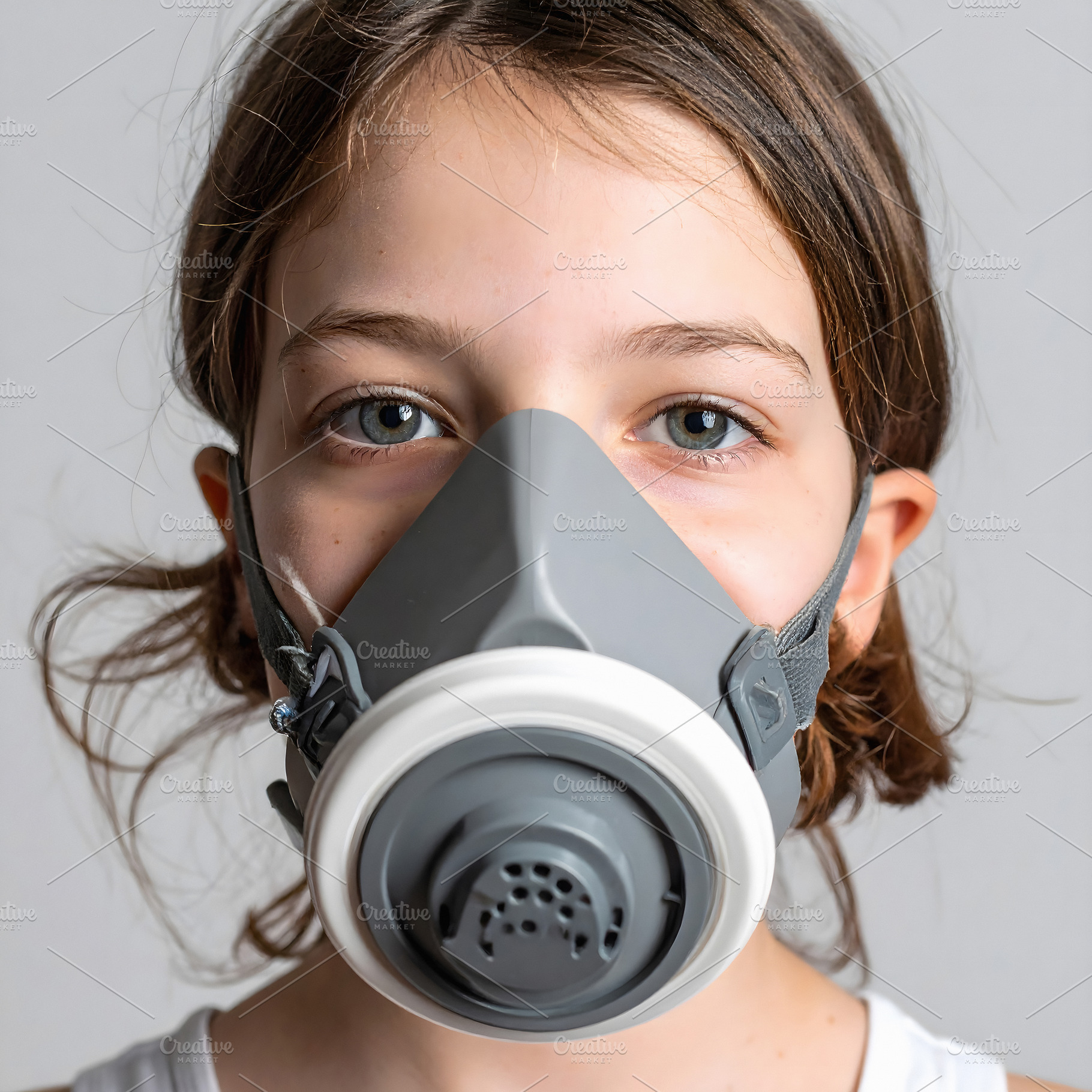 Girl with brown hair wearing large gray respirator mask, a Person Photo by GoodGoods