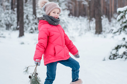 Little girl in a bright jacket plays in the winter forest, a Person Photo by Olena Rudo
