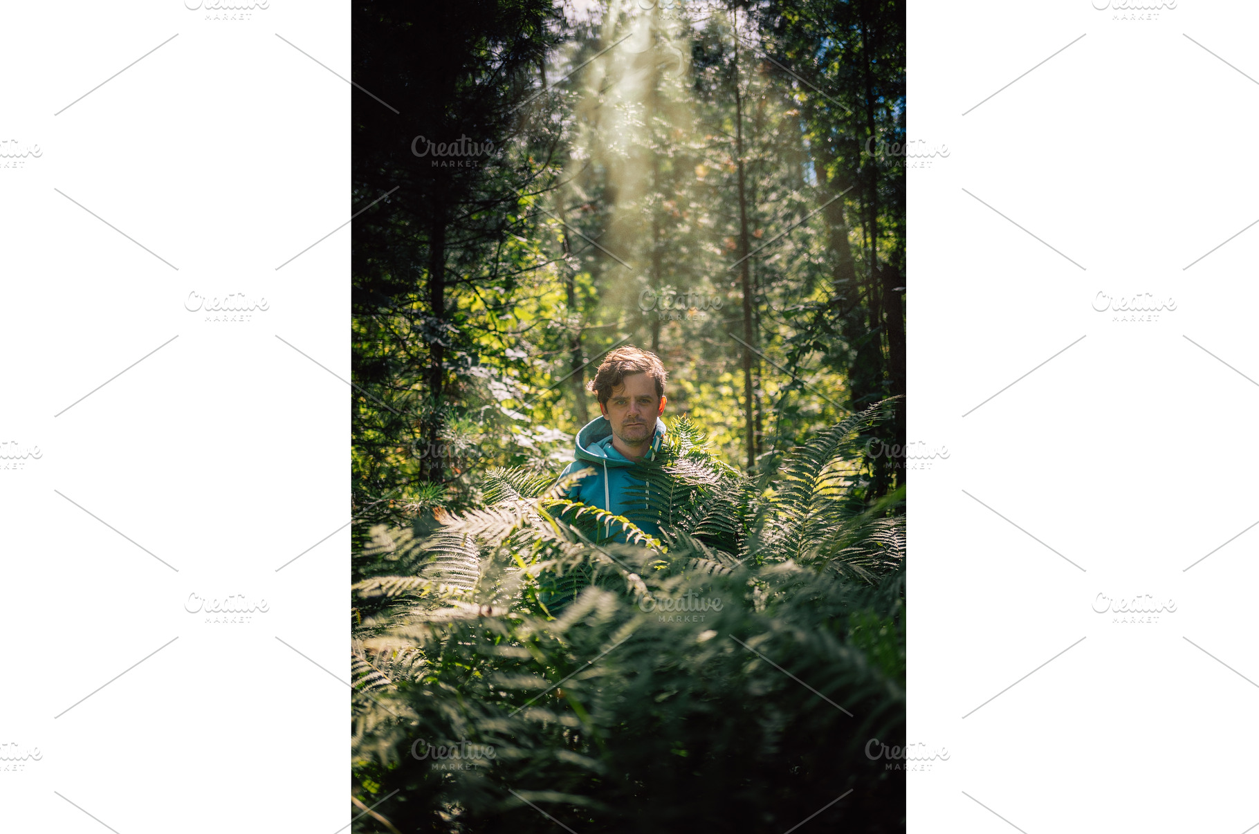 Man standing in green forest, a Person Photo by Jan Jack Russo Media