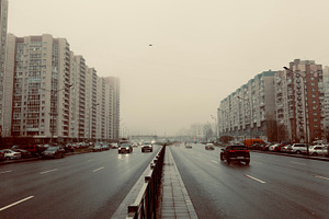 A wide urban road lined with tall residential buildings, cars driving under a c, an Industrial Photo by Textures & Backgrounds
