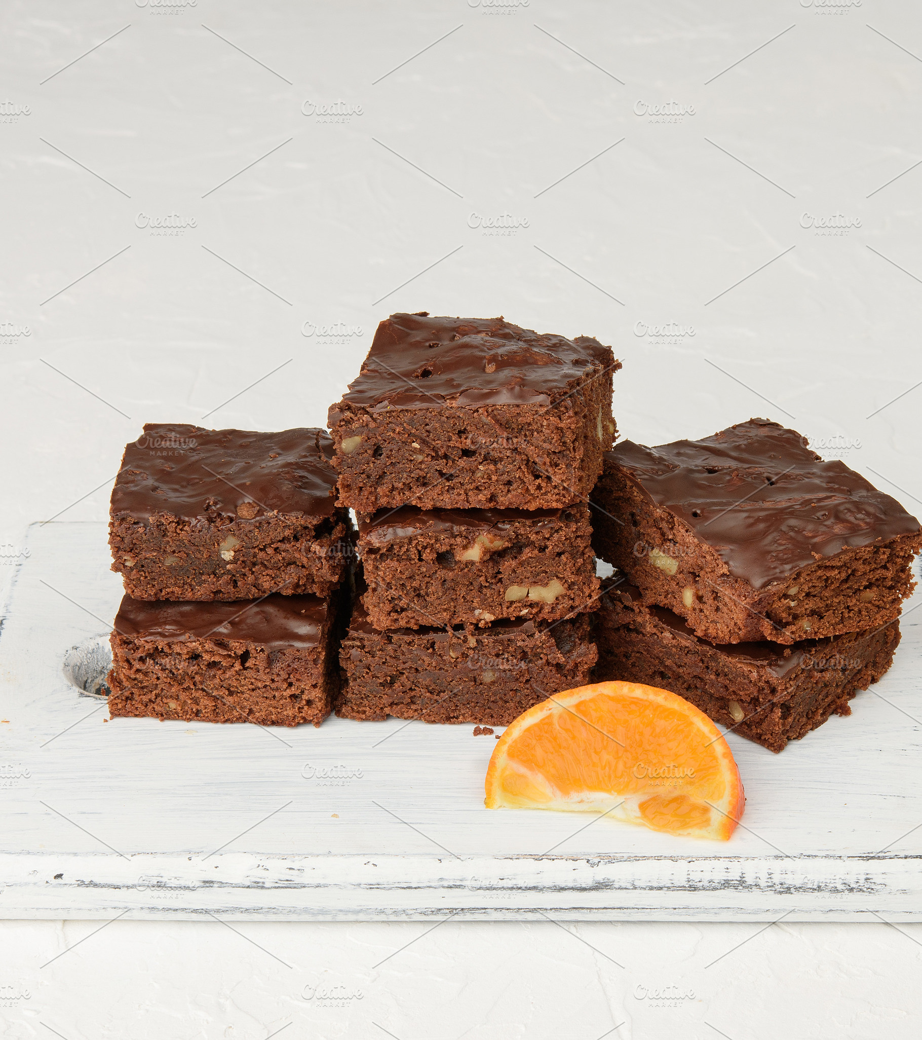 Stack of square baked slices of brownie chocolate cake with waln, a Food & Drink Photo by ndanko