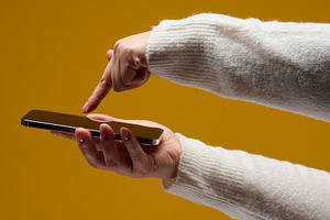 Woman using a smartphone against a yellow background, a Technology Photo by ndanko