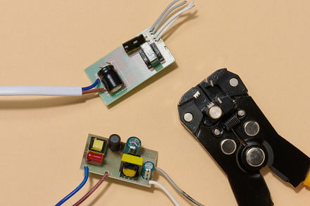 Two green electronic boards with components and wire stripper on
