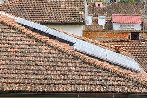 Solar panels with bird protection mesh on a tiled roof, an Architecture Photo by Antonio Gravante Market