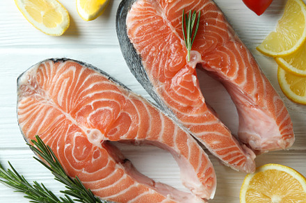 Concept of cooking salmon on white wooden table, a Food & Drink Photo by AtlasStudio