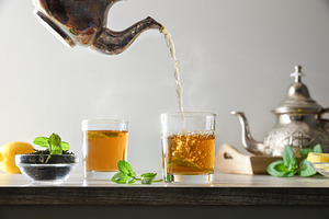 Pouring green tea from a metal teapot isolated background, a Food & Drink Photo by Davizro's Market