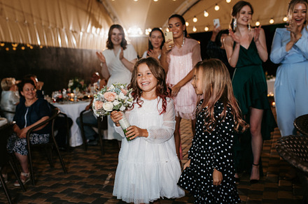 bride in a white dress throws a wedding bouquet