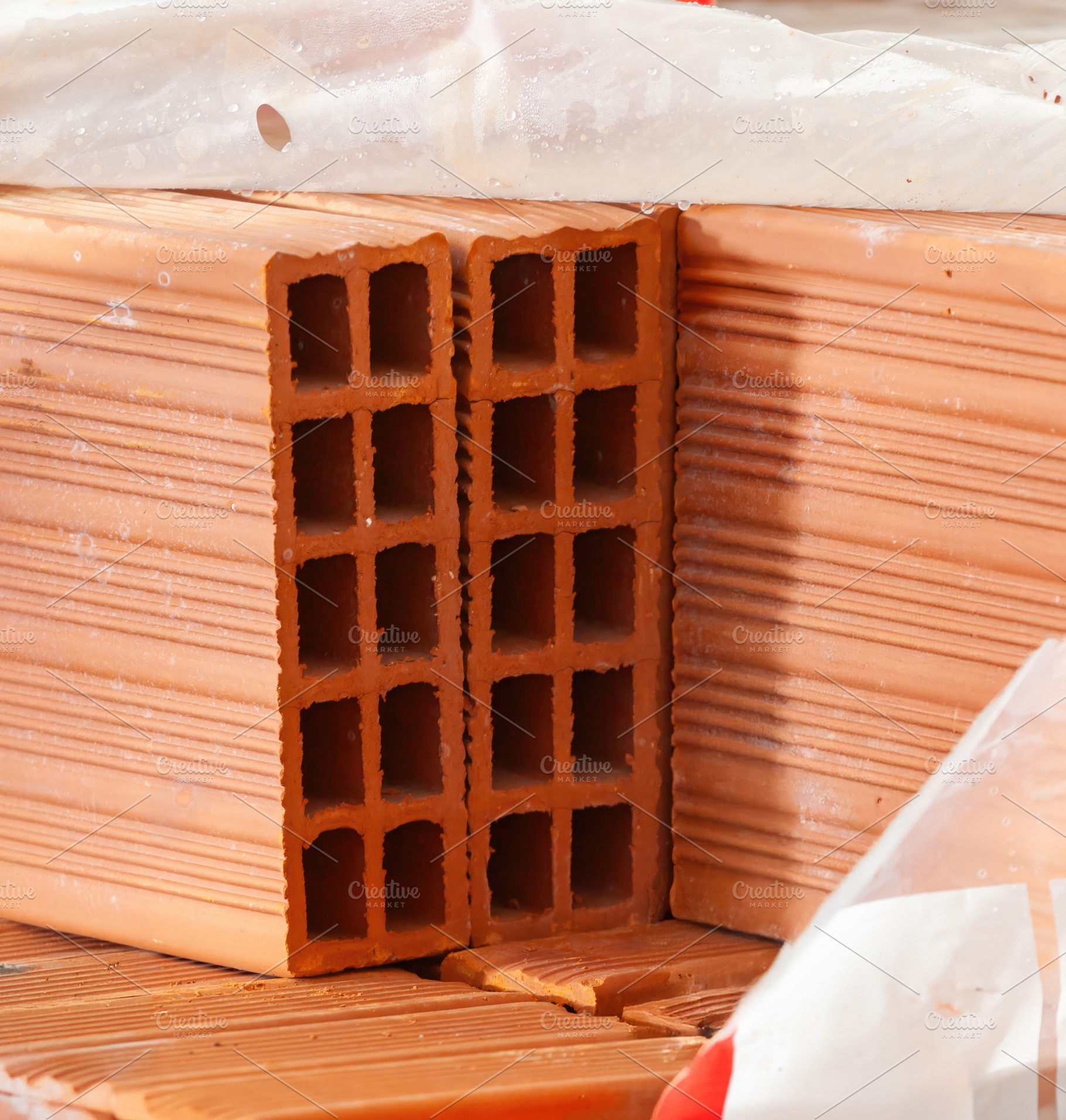 Close up of hollow clay bricks showing square holes, creating a geometric patte, an Industrial Photo by Antonio Gravante Market