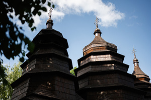Traditional wooden church structure under a blue sky with scattered clouds, a Photo by AS photostudio