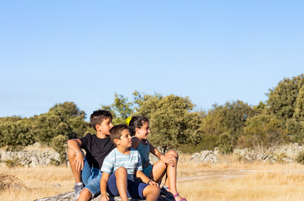 Three kids  with on a top of a rock on their summer vacation