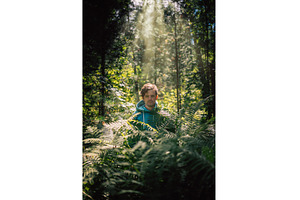 Man standing in green forest, a Person Photo by Jan Jack Russo Media