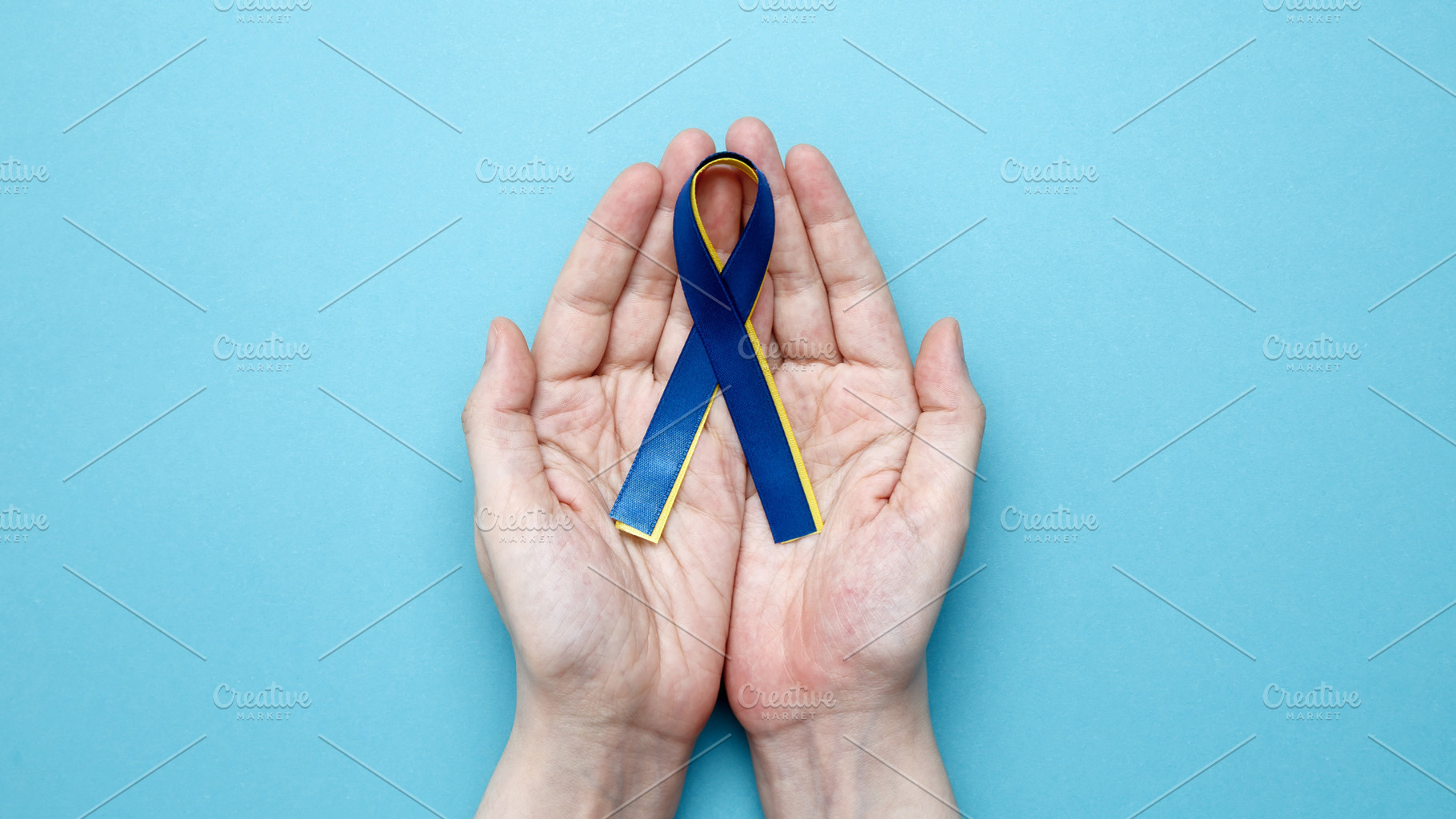 Symbolizing World Down Syndrome Day. A person holds a yellow and blue awareness, a Photo by matucha