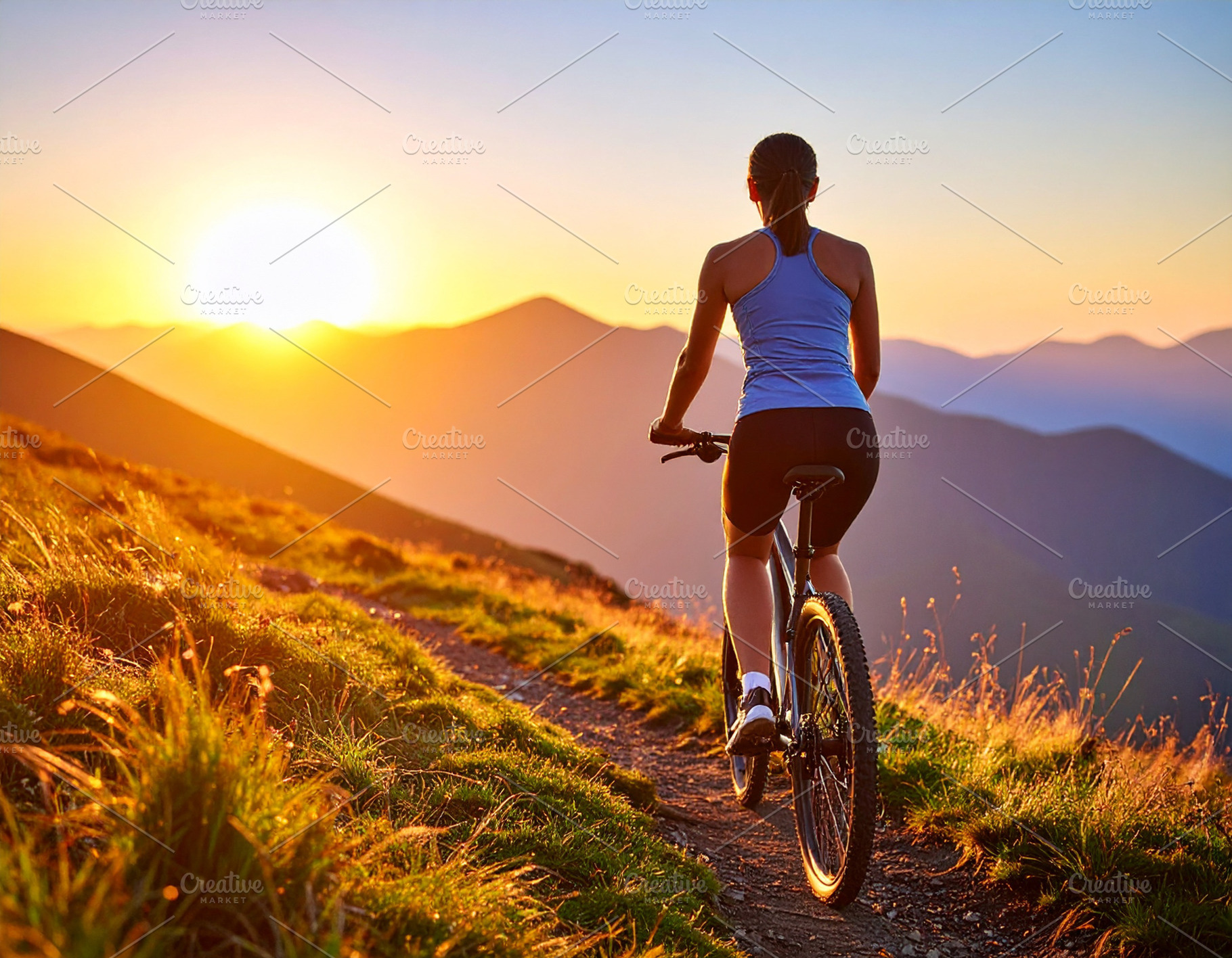 Young cyclist riding on a mountain trail at sunrise, a Sports & Recreation Photo by DanFLCreativo