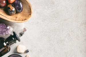 Crystal Healing Stones and Essential Oil Bottles on Gray Backgro