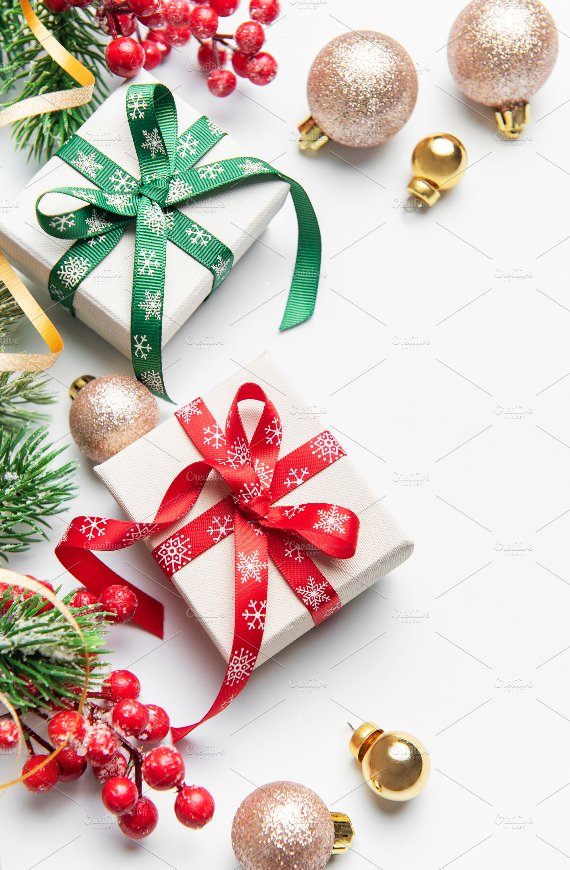 Christmas gifts decorations with holly and ornaments on white, a Holiday Photo by Olena Rudo