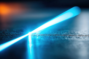 Macro shot revealing dark brushed steel with focused blue light reflection, a Background Photo by AlyaAnd
