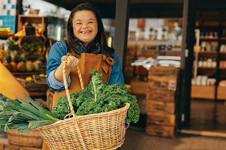 Grocery store employee with down syndrome holding a basket of fr, a Person Photo by Jacob Lund