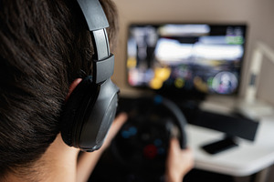 Person gaming with steering wheel controller in home setup for virtual simulati, a Photo by AS photostudio