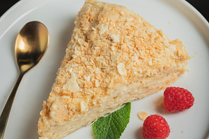Sliced Napoleon cake on a white wooden table. Classic dessert