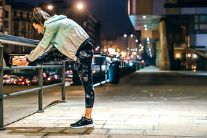 Woman runner stretching her legs over banister before training a, a Sports & Recreation Photo by davidpereiras