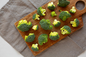 Raw Organic Green Broccoli on a Wooden Board, top view., a Food & Drink Photo by LiudmylaChuhunova