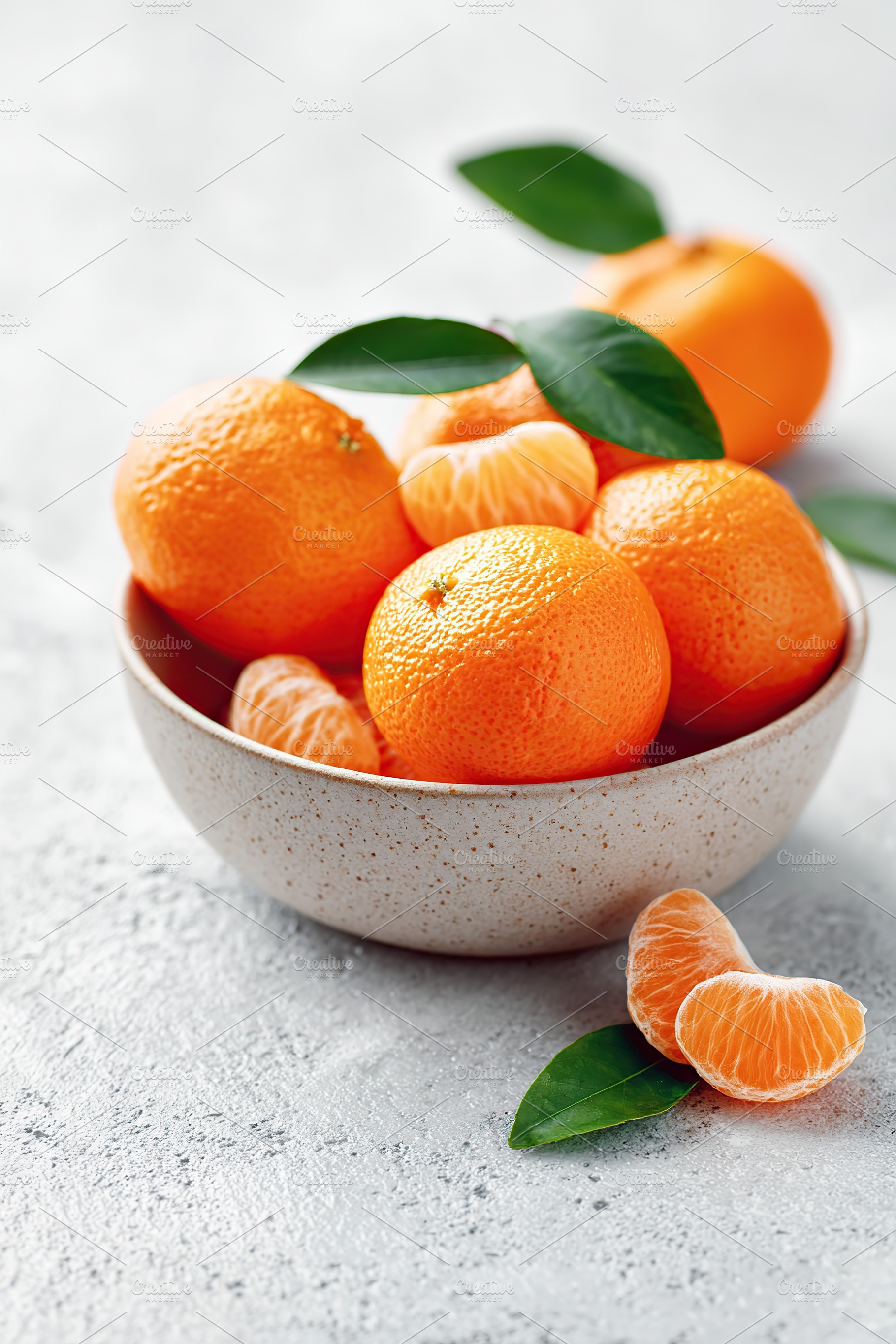 Peeled mandarin segments and whole fruit arranged in a smooth ceramic bowl for, a Food & Drink Photo by AlyaAnd