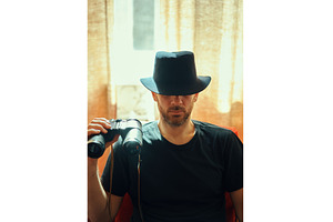 Mysterious man in black hat holding, a Person Photo by Gladkov photography