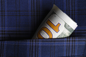 Close-up of a rolled U.S. dollar bill tucked into a blue plaid fabric pocket, h, a Business Photo by Ales Munt
